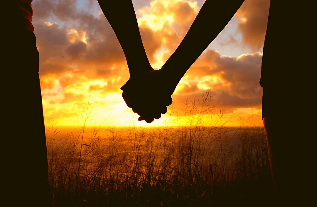 Couple holding hands at sunset — intimacy and sexual health